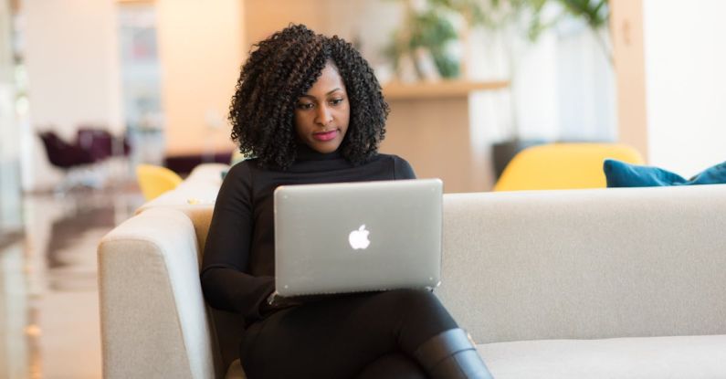 Laptop - Woman Using Macbook Sitting on White Couch