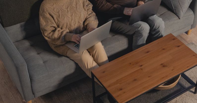 Laptop - Man and Woman Sitting on Gray Couch