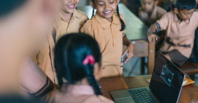 Laptop - Students Standing Beside the Wooden Table