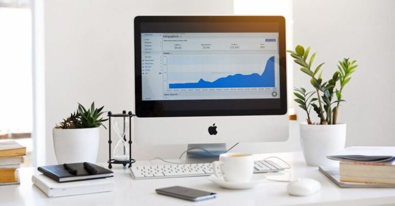 Computer - Silver Imac Displaying Line Graph Placed on Desk