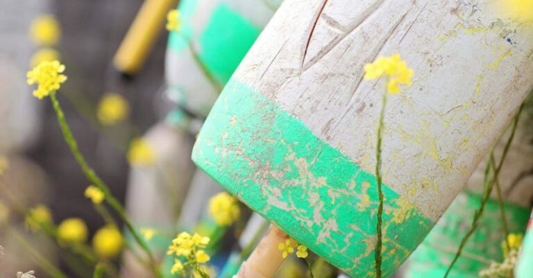 Codding - Weathered lumber concrete cone shaped cylinders in green summer garden during sunny day