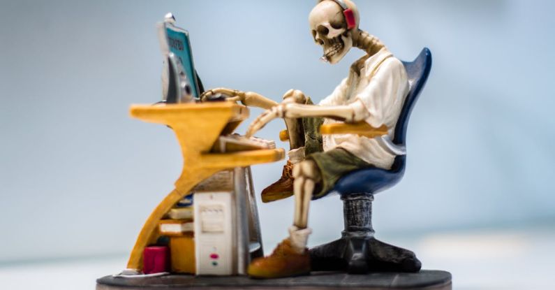 Computer - Figurine of Human Skeleton Sitting Infront of Computer